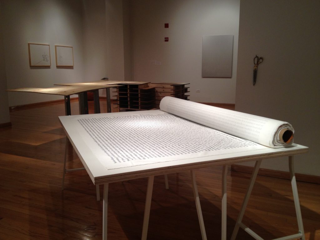 A table with a scroll of fabric printed with text