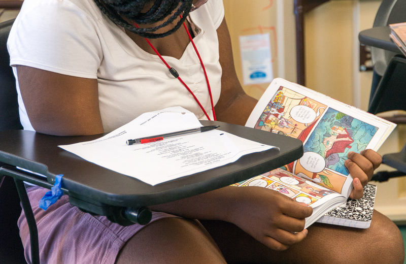 Student looking at a graphic novel