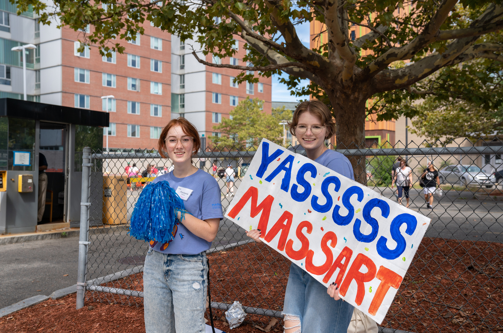 Two students holding up a sign that says YASSSS MASSART