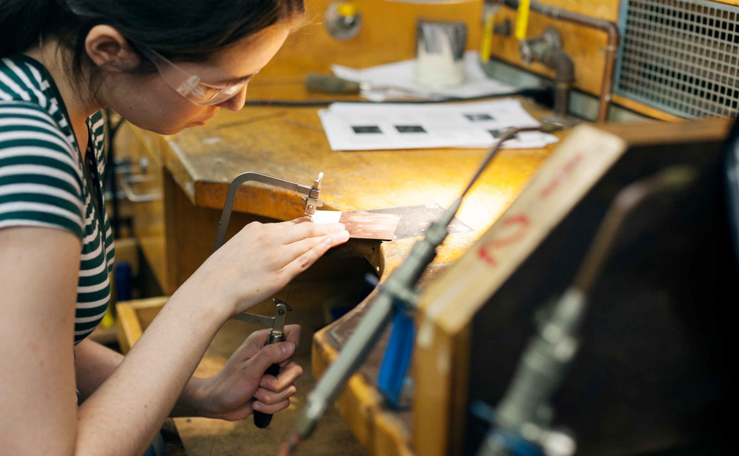 © Nathan Ouellette '14 BFA Photography Jeweler working on a piece at a jeweler's bench