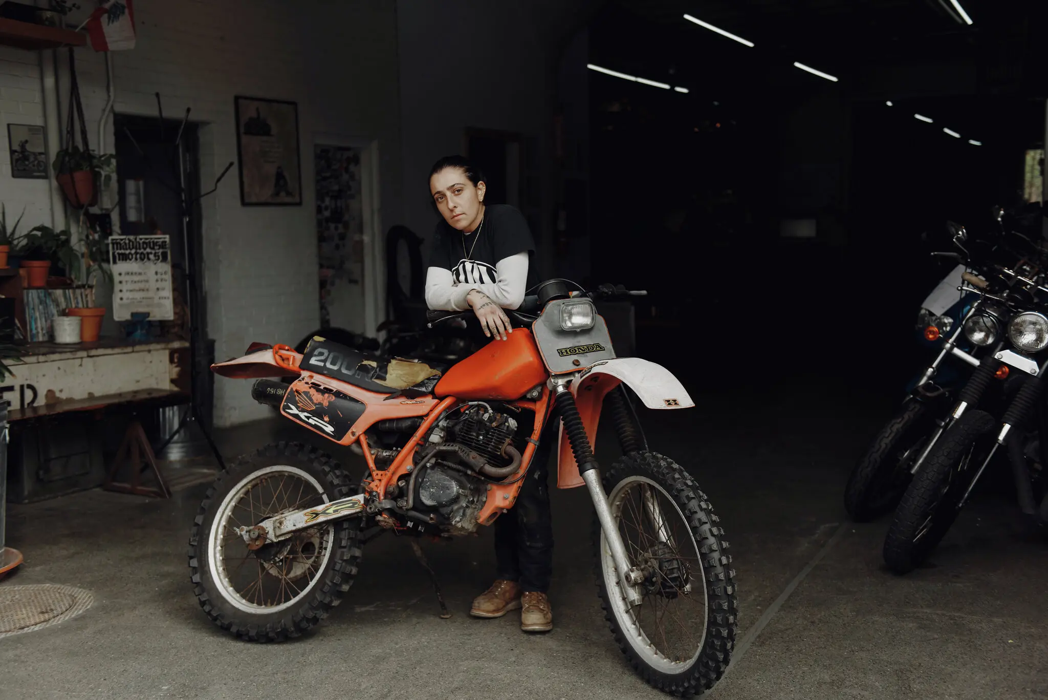 Photograph of J. Shia with a motorcycle at Madhouse Motors in Roxbury, MA. Image by MassArt Alumnus, Tony Luong, courtesy of The New York Times Photograph of J. Shia with a motorcycle at Madhouse Motors in Roxbury, MA.