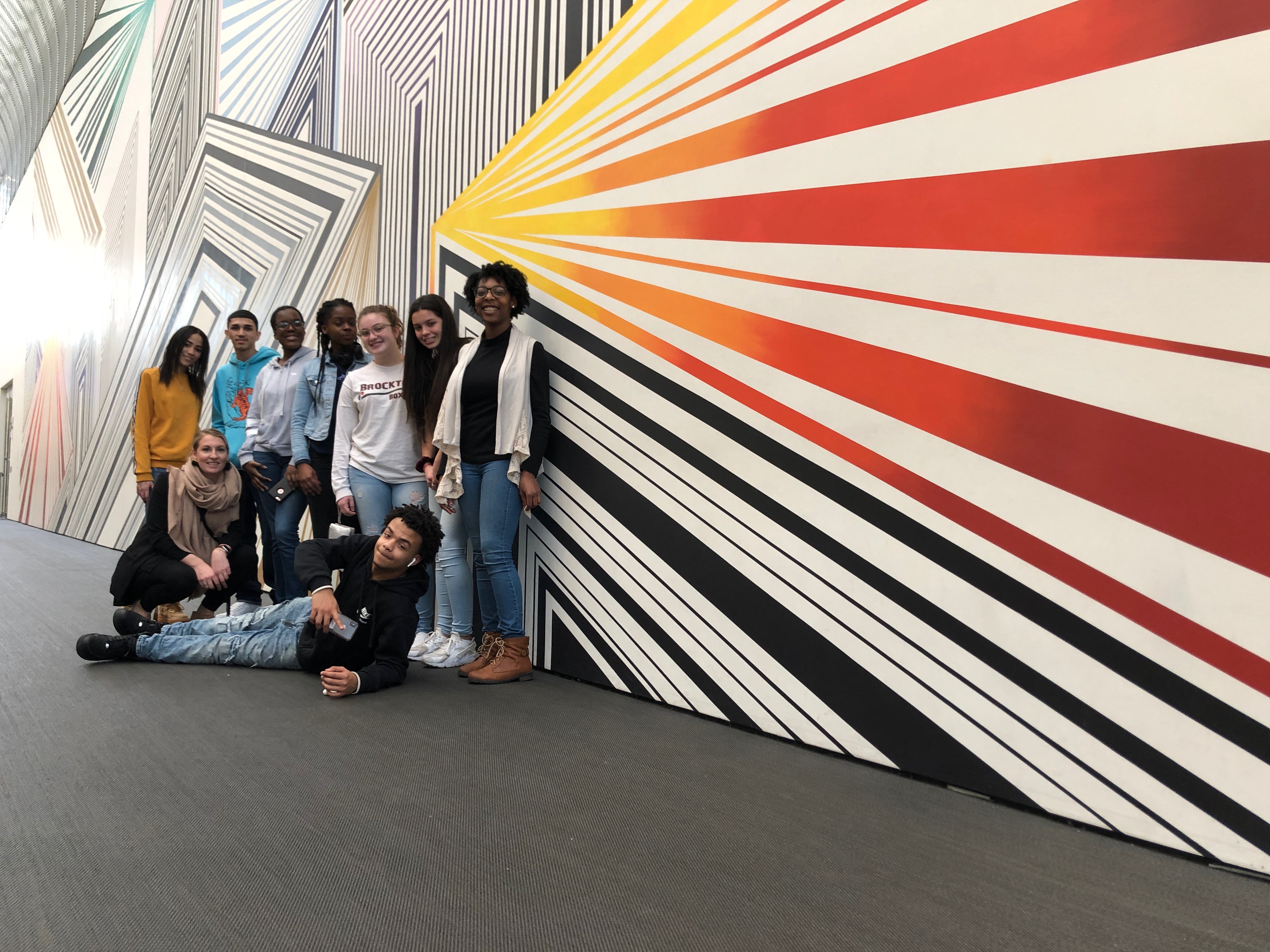 Melanie blood and her high school students in front of her mural